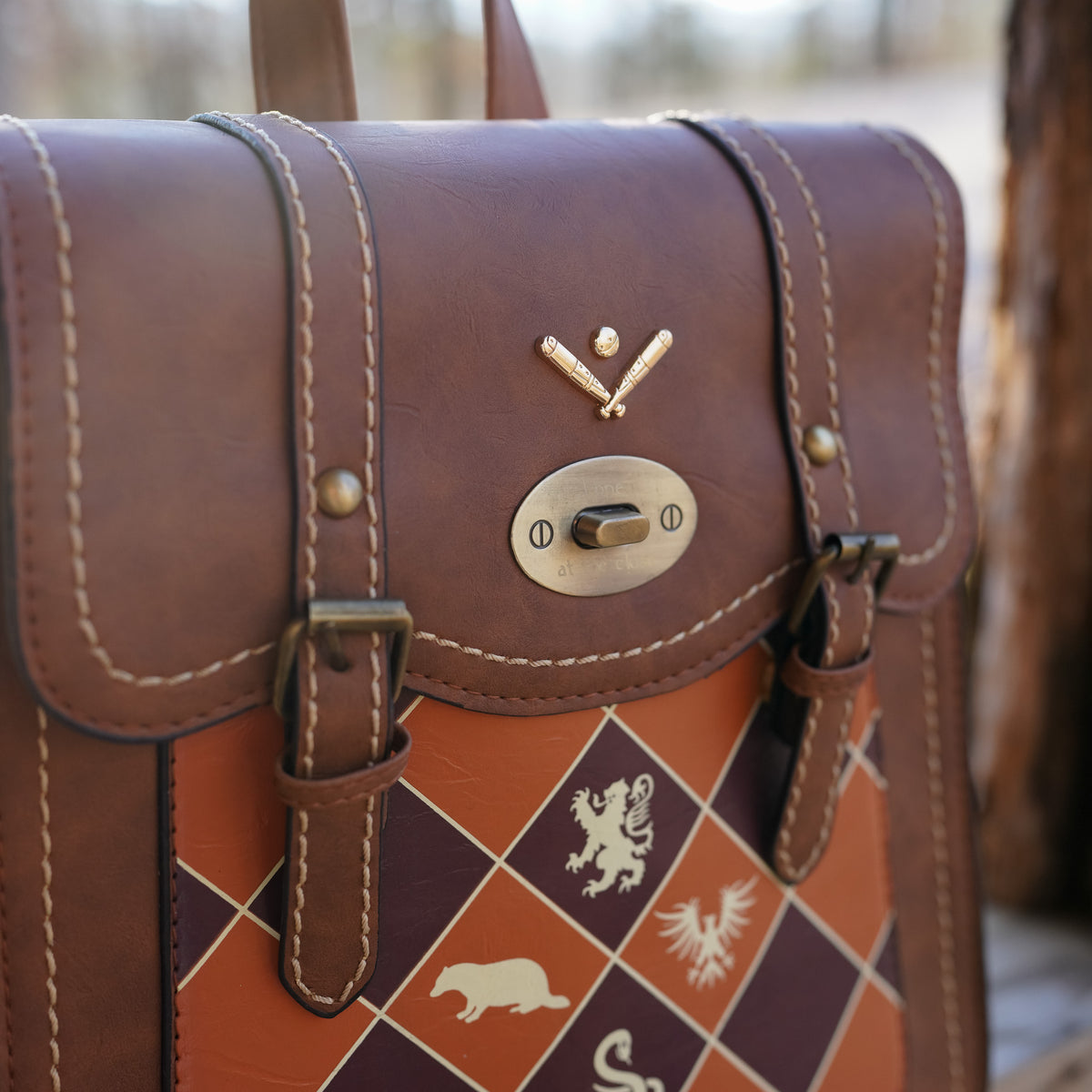 Magical Sports Backpack is made of brown leather, orange and maroon checkers and gold details
