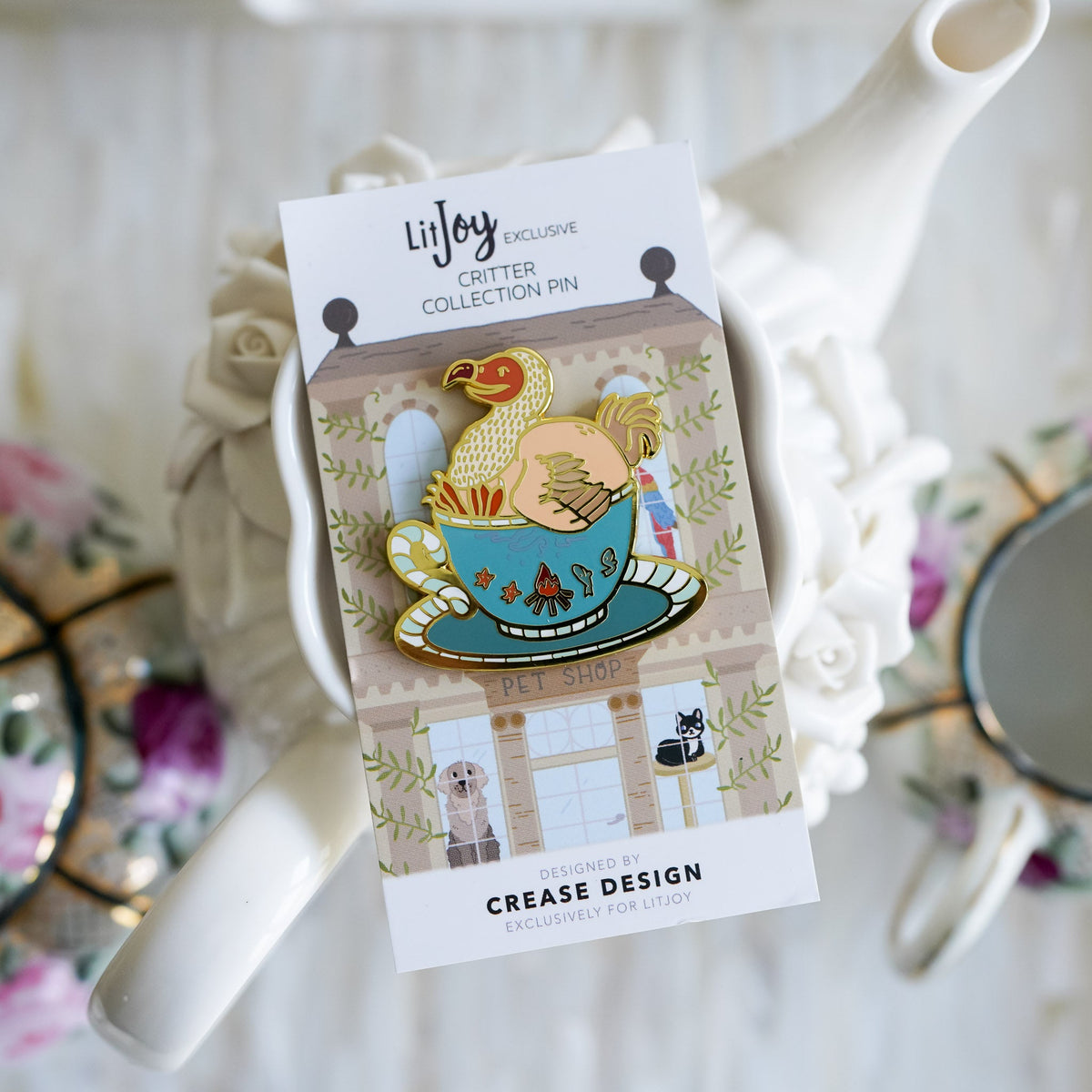 Dodo Bird Critter Collection Enamel Pin with a bird sitting inside of a teacup on top of a saucer.