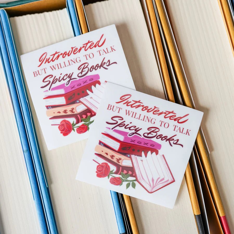 Introverted But Willing to Discuss Spicy Books Sticker has a stack of books with hearts and roses