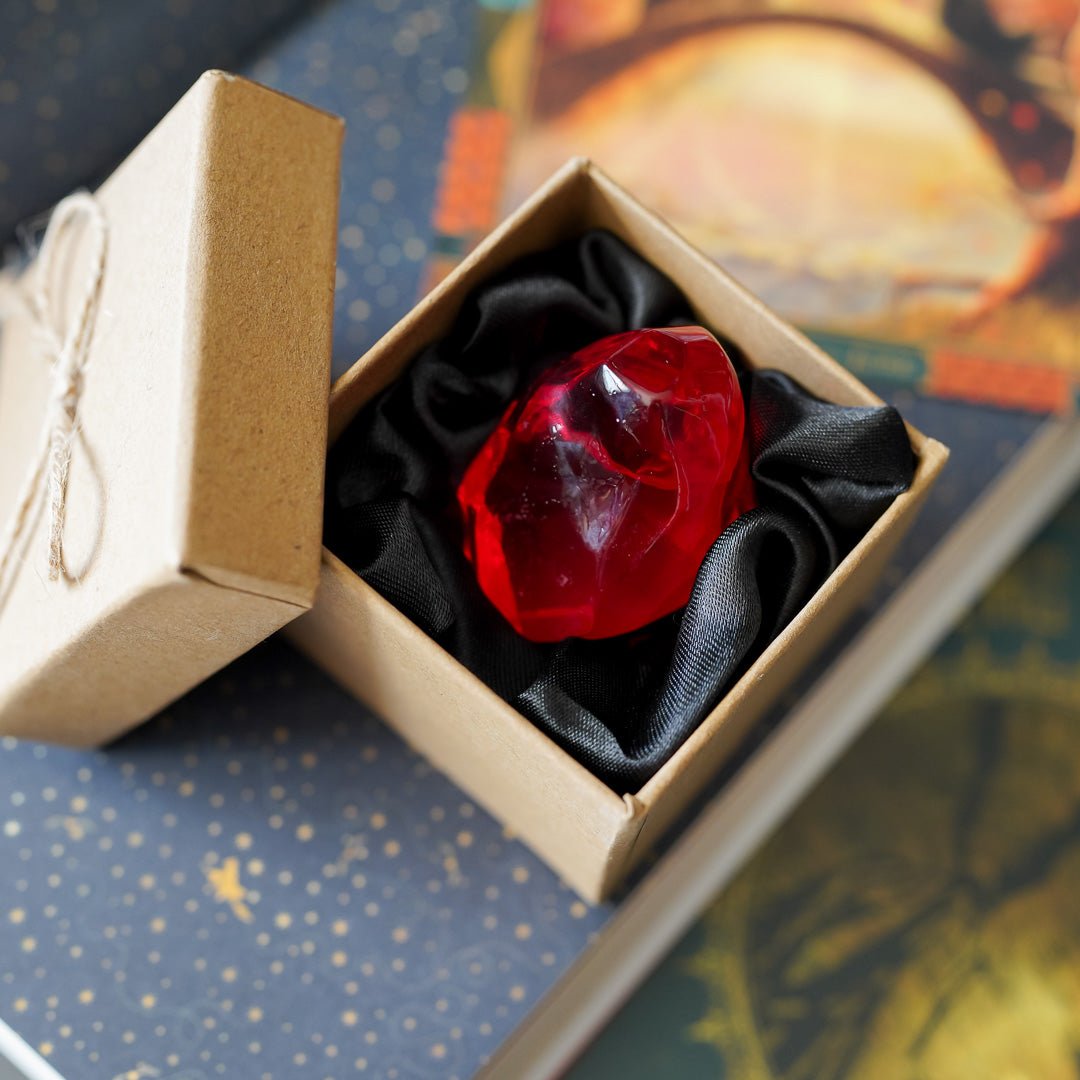 Philosopher&#39;s Stone is a ruby red stone in a brown kraft bow with a black silk interior
