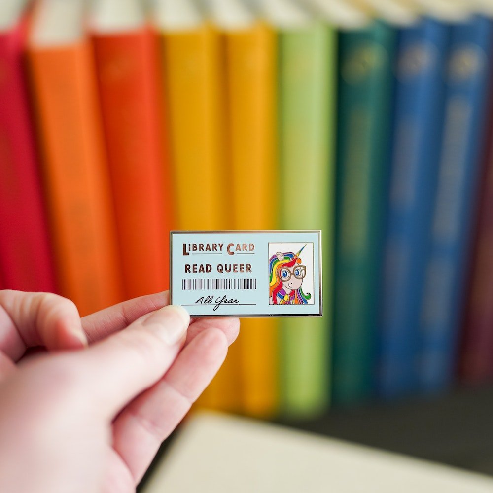Pride Pin with library card design that reads &quot;Library Card, Read Queer&quot; 