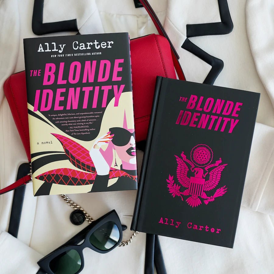 The Blonde Identity by Ally Carter is a black and pink book with a blonde woman wearing black sunglasses and a plaid scarf.