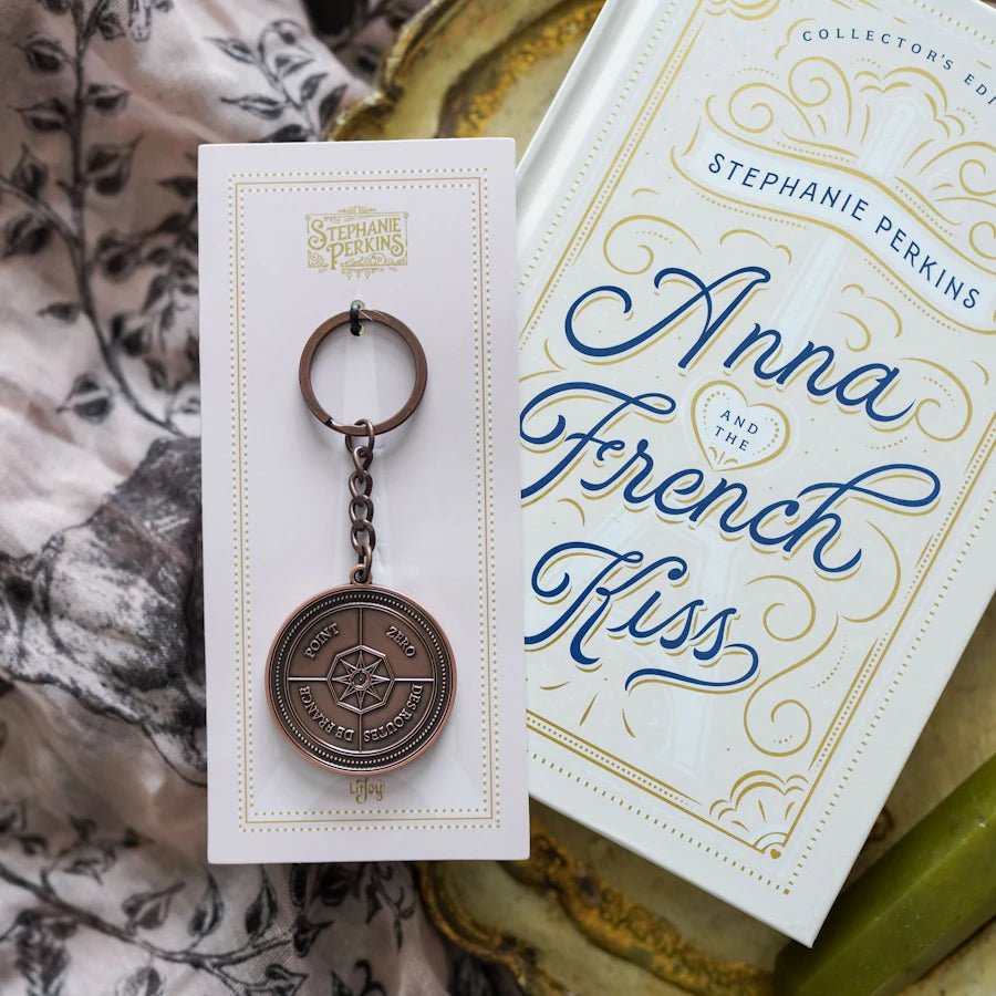 Anna and the French Kiss Coin Keychain features Point Zero in Paris on an antique copper plated coin attached to a keychain.