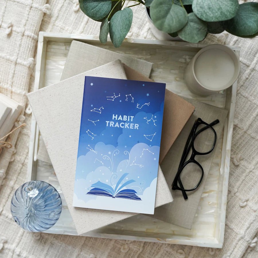 Build Your Own Planner: Habit Tracker—a blue ombre mini journal with open book, clouds, and zodiac constellations on cover