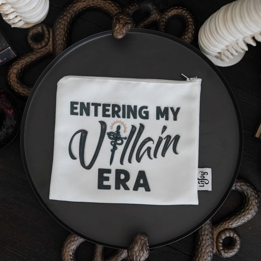 A white polyester canvas zipper pouch with the phrase "Entering My Villain Era" in black.