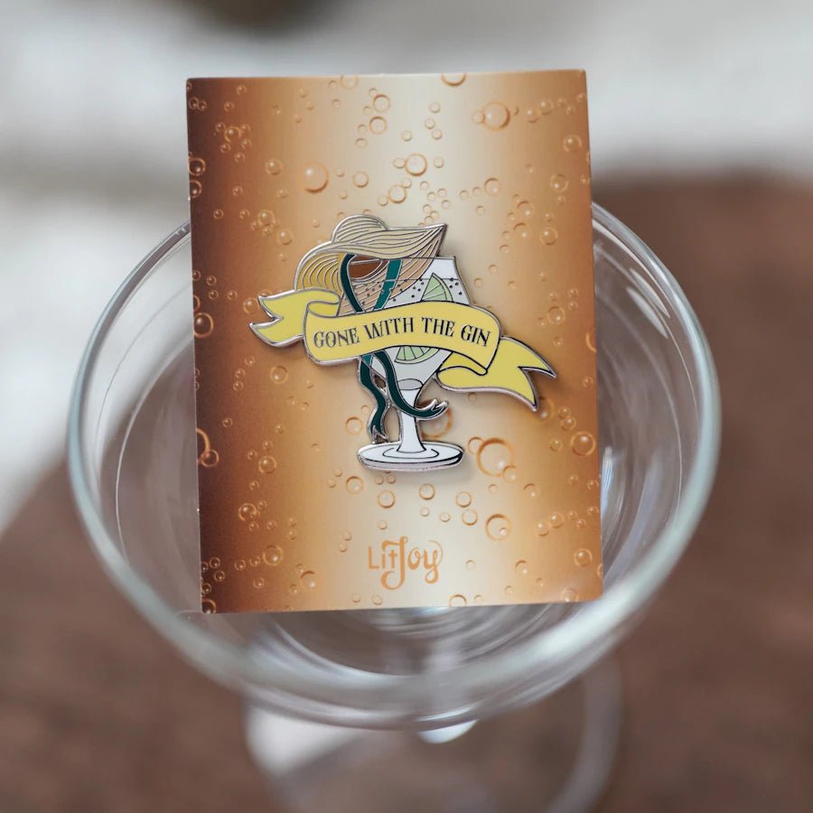 Gone With the Gin Cocktail Enamel Pin shaped like a glass of gin and garnished with a lime and bonnet