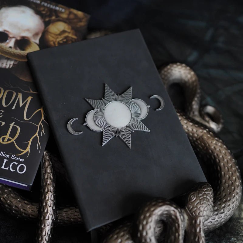 Kingdom of the Wicked La Prima's Grimoire Replica Notebook with moon metal detail, aged faux leather, & 200 blank black pages