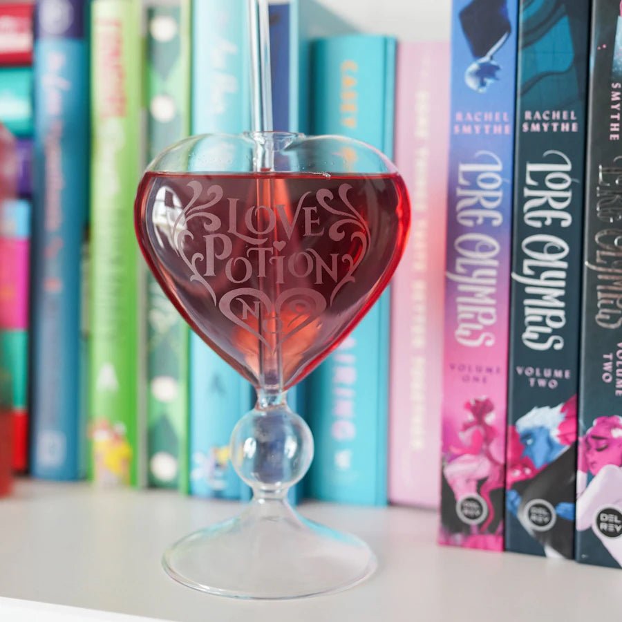 Love Potion Glass is a heart-shaped drinking glass with &quot;Love Potion No. 9&quot; etched on it and a curved glass straw