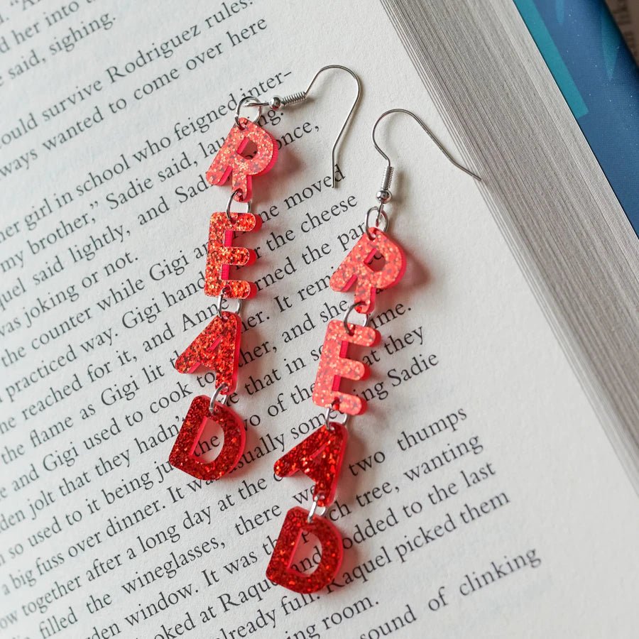 LitJoy&#39;s Read Acrylic Earrings are shimmering red earrings that spell out the word READ in dangly letters on each one.