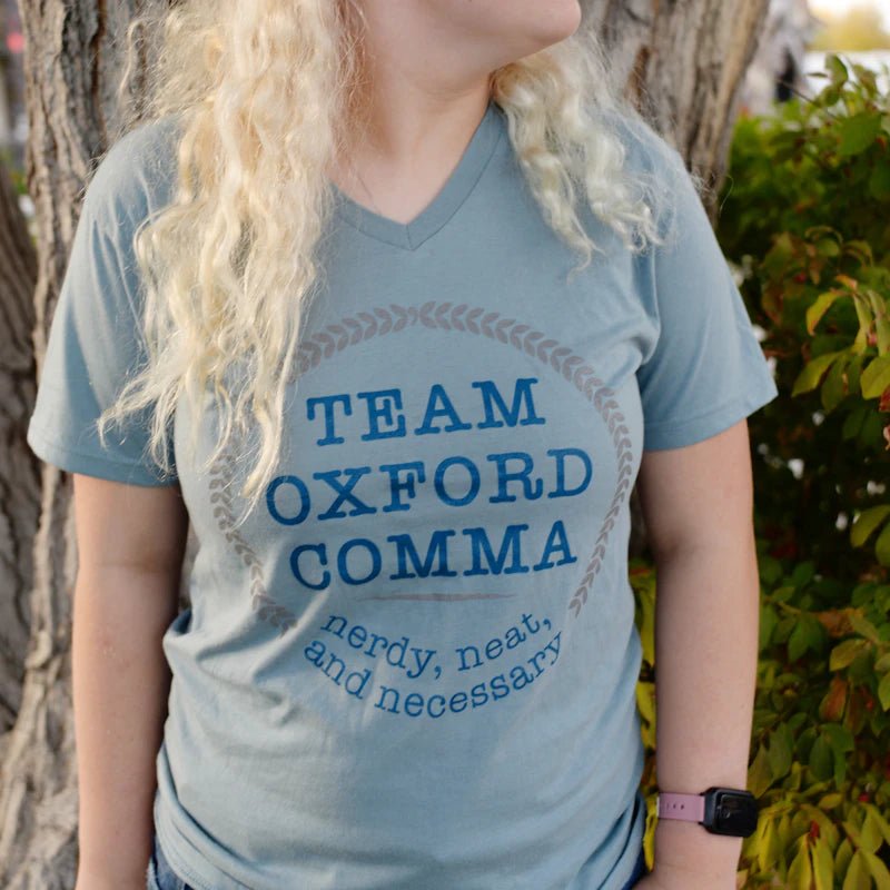 Team Oxford Comma Shirt is a dusty blue v-neck shirt that reads: &quot;Team Oxford Comma | nerdy, neat, and necessary&quot;