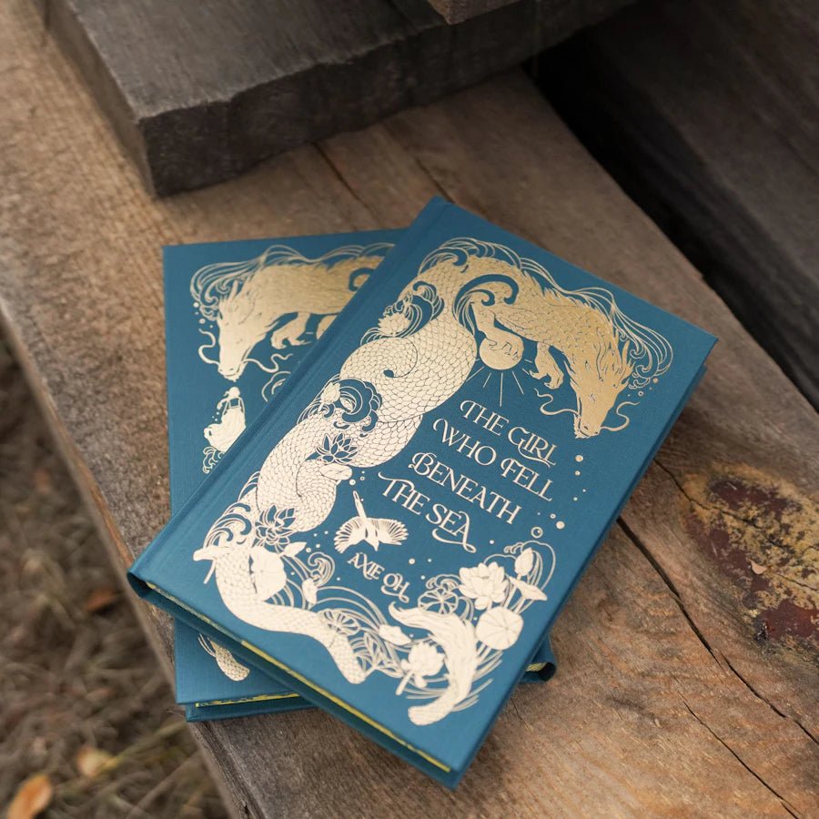 A sea dragon winds around the Wibalin cover in gold foil along with hidden images from the story.