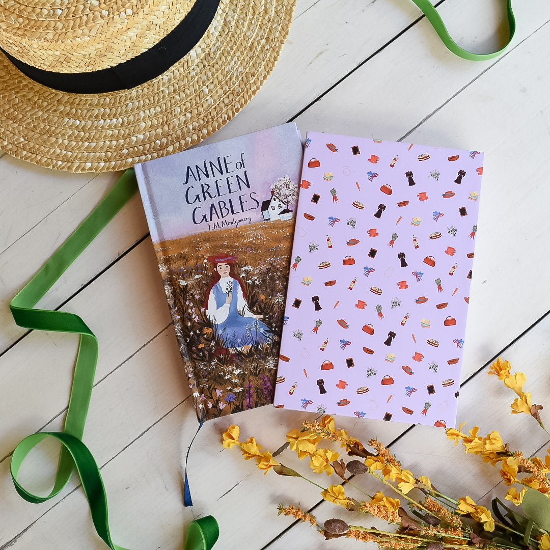 Anne Of Green Gables by L.M. Montgomery hardback book in purple with cover artwork of Anne. Slipcase has carrots, puff sleeves, and more!