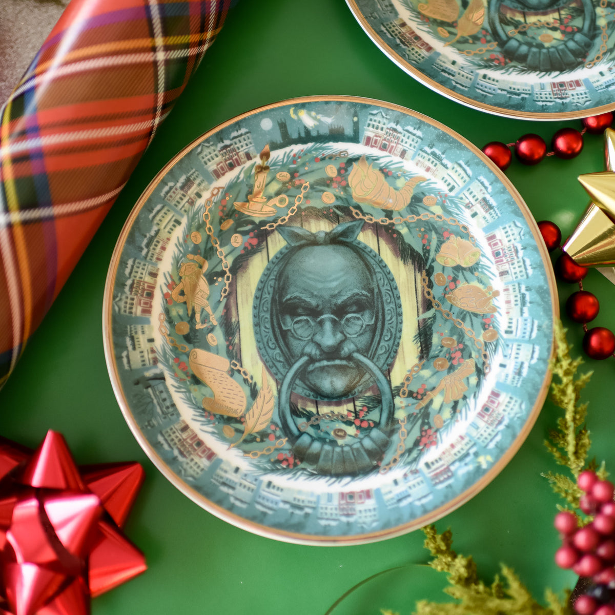 A Christmas Carol Dessert Plate features Marley as Scrooge&#39;s door knocker, 1800s English, garland, holly, and gold rim edge