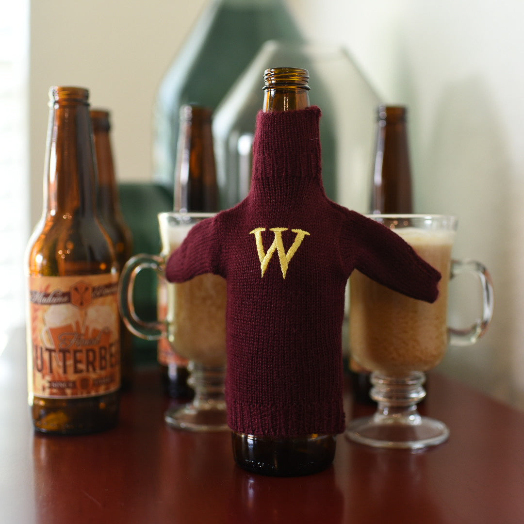 Magical Family Mini Sweater is on a bottle and is maroon with a yellow &quot;W&quot; embroidered on the front