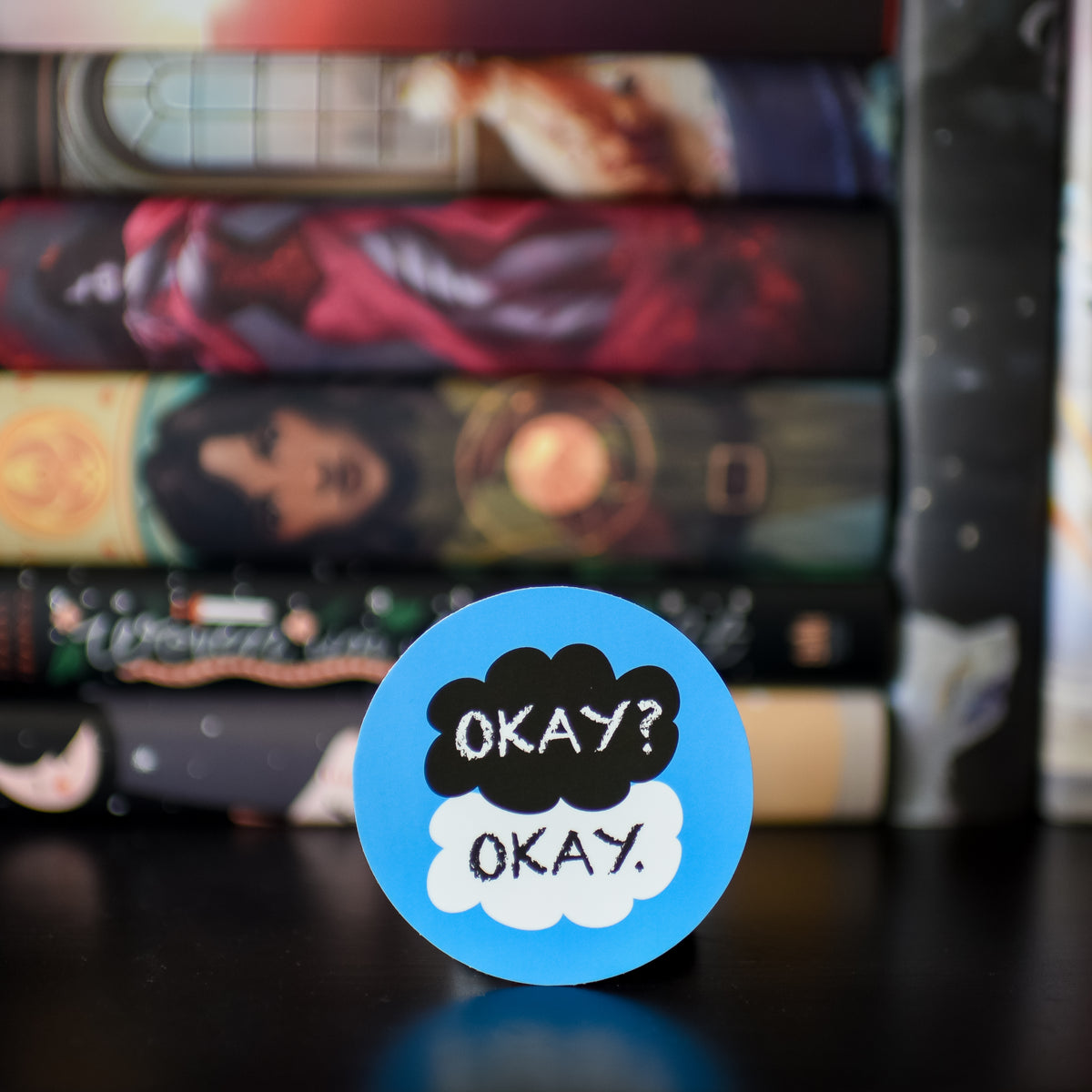 The Fault in Our Stars Sticker is a blue circle and a black cloud and a white cloud with the words &quot;Okay? Okay.&quot;