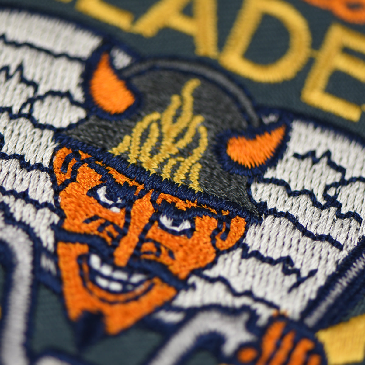 Speed Reader Patch with a closeup of an orange faced devil riding a bike with a book behind him