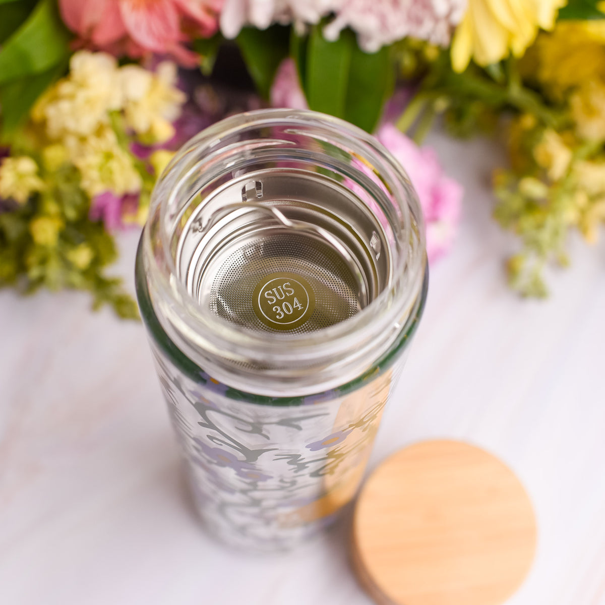 The Secret Garden Glass Water Bottle with bamboo lid and a tea or fruit infuser in the top