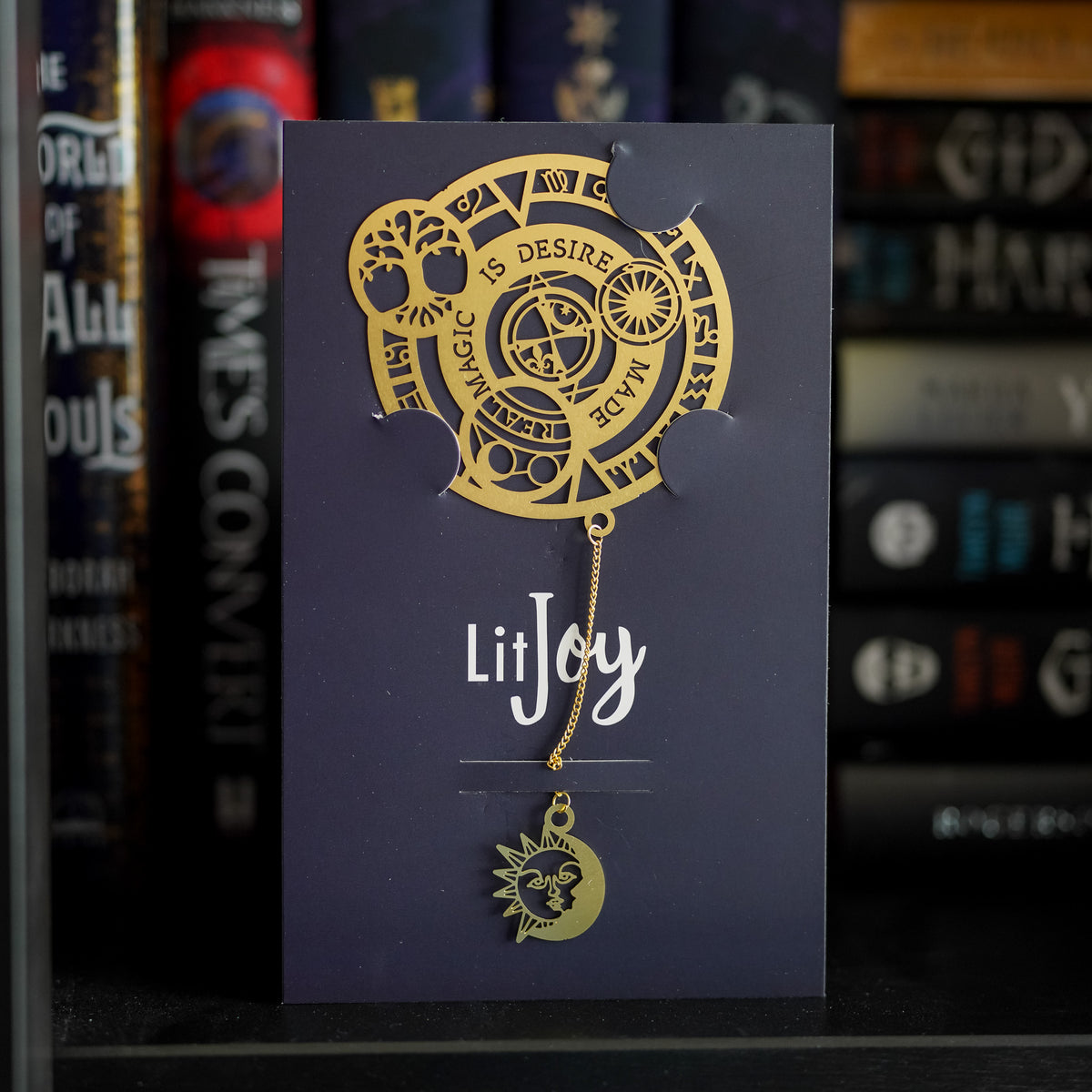 Witch Discovery Metal Bookmark is a gold bookmark with a circular top that says &quot;Magic is desire made real&quot; and a hanging moon and sun