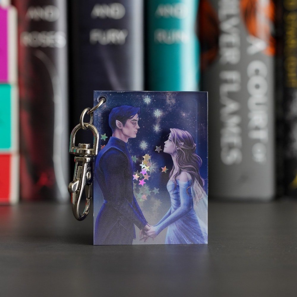 Purple and silver ACOTAR Starfall Keychain has Feyre and Rhysand holding hands with silver stars behind them.