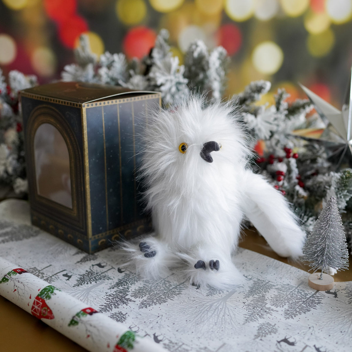 Adopt a Magical White Owl Plush with box cage and white owl stuffed animal surrounded by holiday wrapping paper and garland