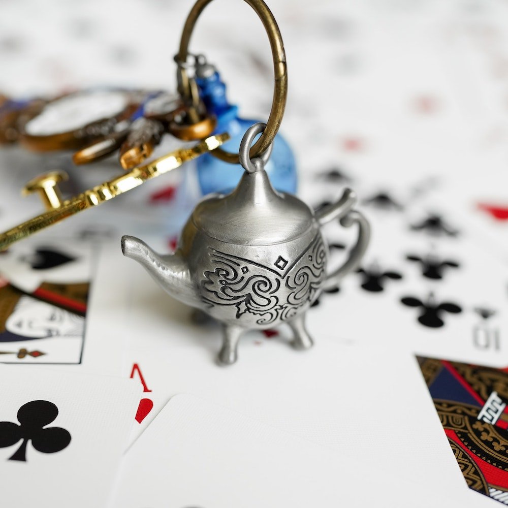 Alice in Wonderland Key shoing the Mad Hatter Teapot charm which is silver with some etched scrollwork.