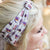 Avid Readers Club Headband with quote "Avid Readers Club" and stacks of multicolored books decorating the band