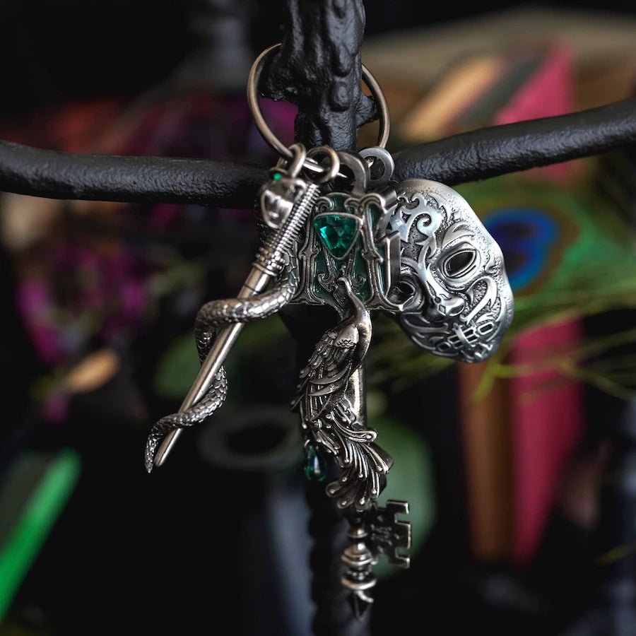 Silver Dark Wizard House Key with green gemstone, peacock, and the letter M. Includes dark wizard mask and snake wrapped around sword charms.