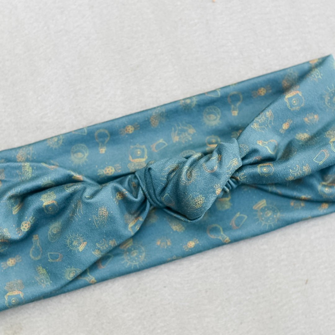 Close-up of blue headban with light cream colored witchy motifs