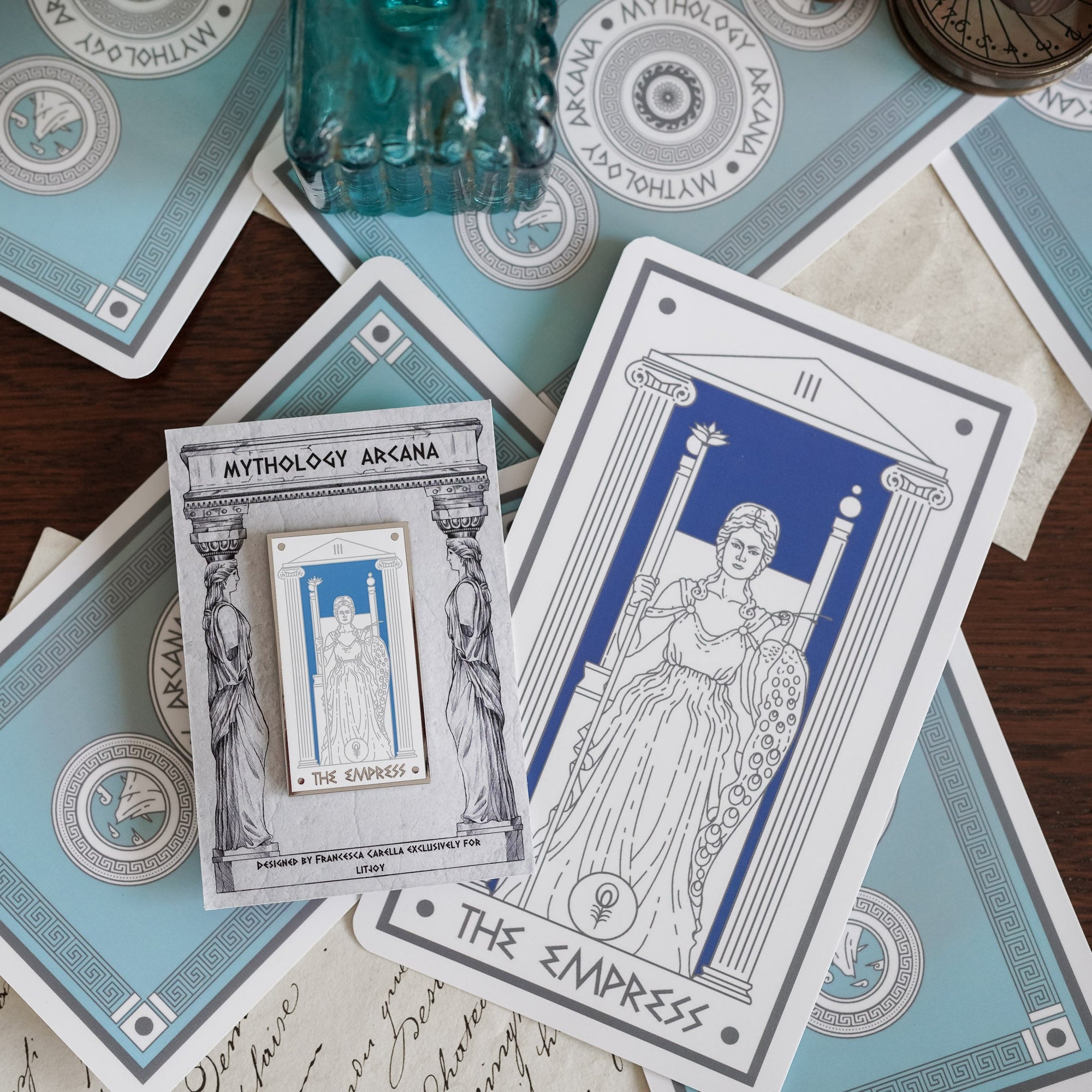 Hera The Empress, Mythology Tarot Enamel Pin with Hera sitting on a throne between two columns and words "The Empress” below.