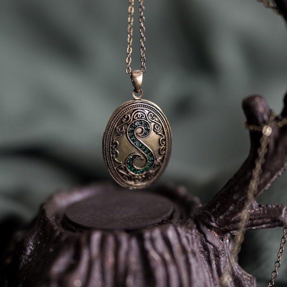 House Locket that is gem-encrusted and with the letter S on the front