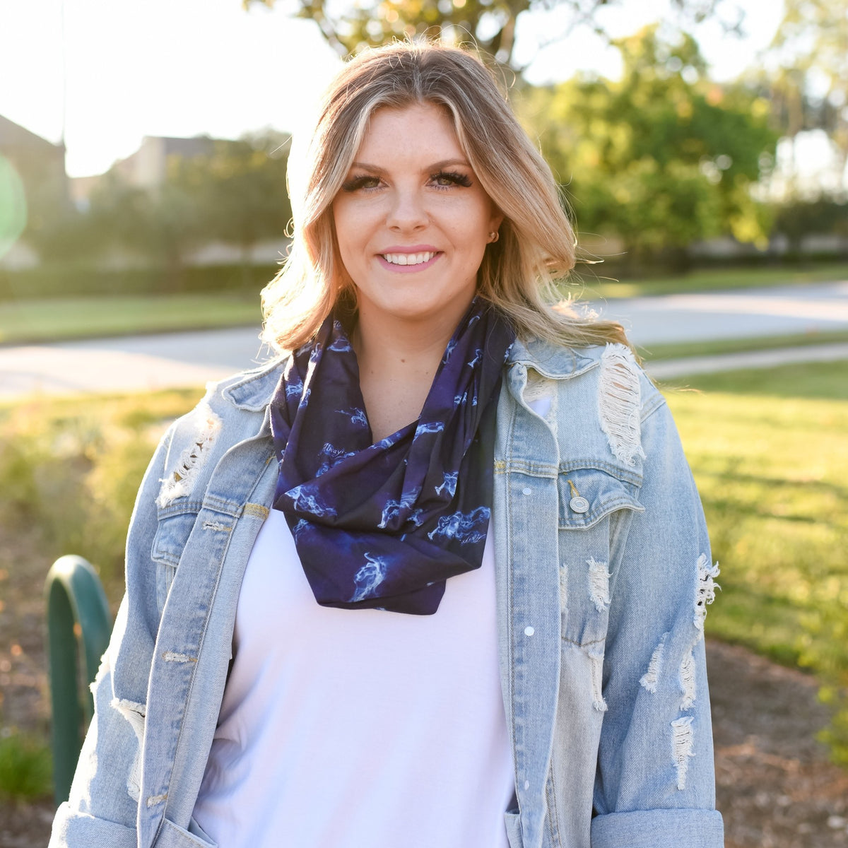 Navy blue and black Magical Animal Familiar Scarf with white wispy creatures worn as an infinity scarf around a woman&#39;s neck