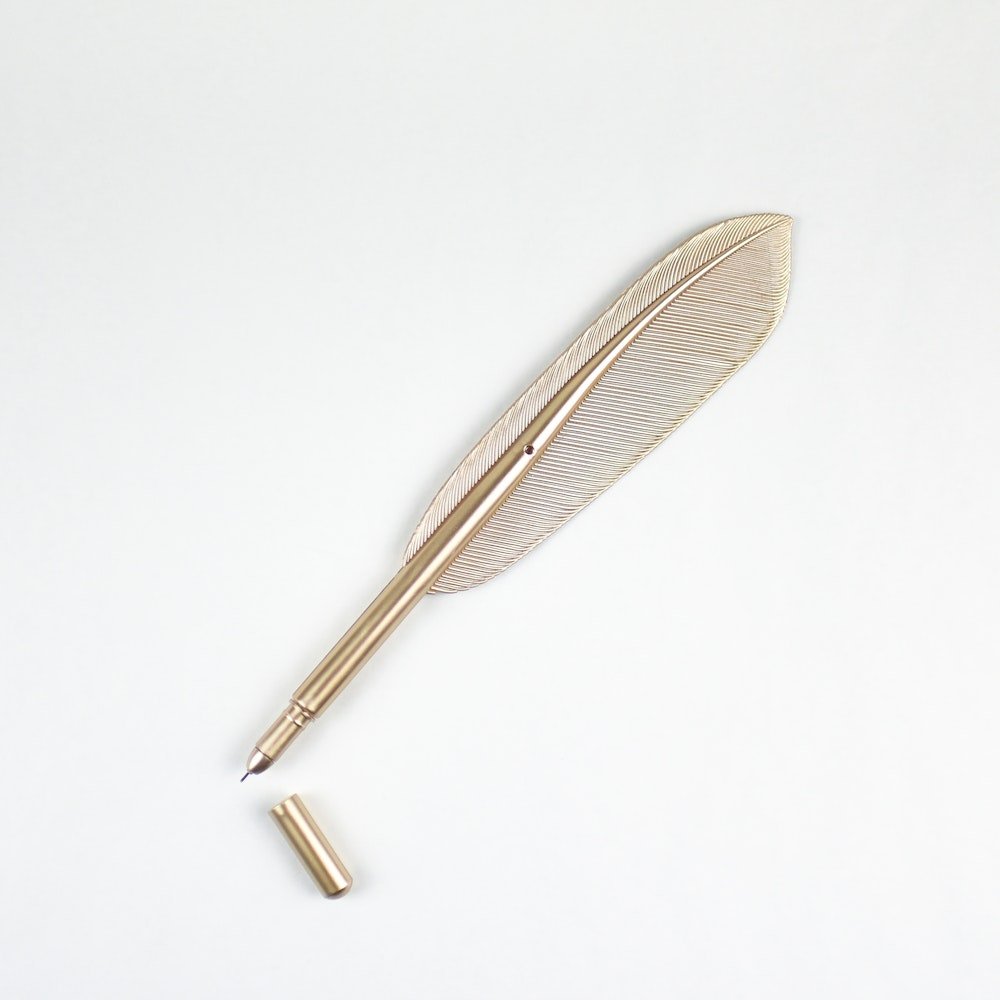 Gold feather pen that comes with the special Pride and Prejudice gift box