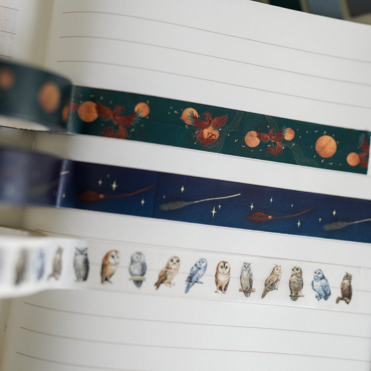 Enchanting Washi Tape has 3 patterns: dark green with orange phoenixes, navy blue with brooms, and white with owls