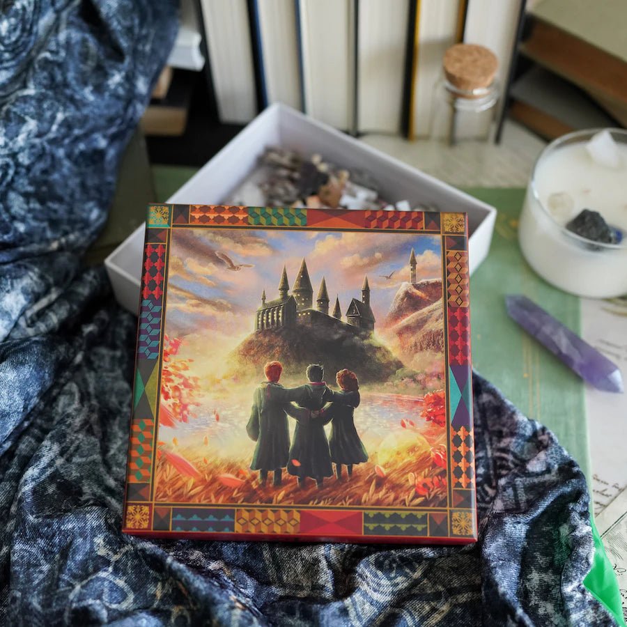 Take Me Home Theme Art Puzzle with an image of three wizard friends gazing at the wizard school castle and grounds with a snowy owl flying overhead.