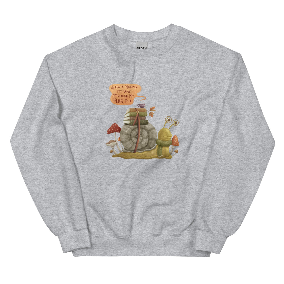 TBR Snail Sweatshirt with books and a teacup strapped to its shell, mushrooms around the snail, and a quote bubble