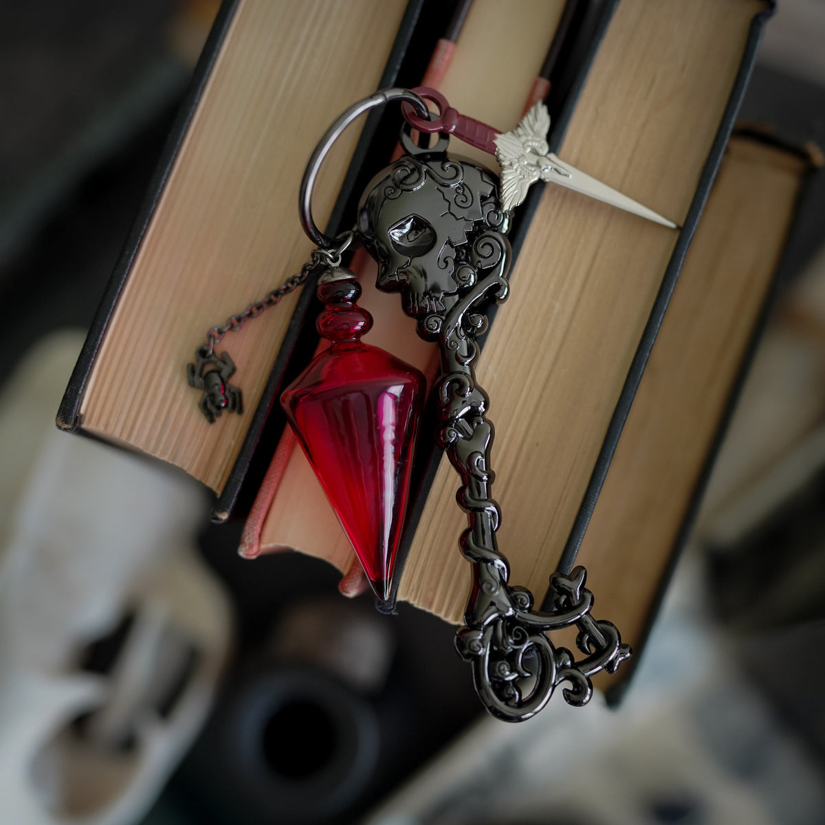 The Red Church Key from Nevernight with skull design and two deadly charms: Mia&#39;s gravebone dagger and a red vial of poison.