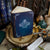 Witch Discovery Book Lamp is a blue book-shaped lamp with white pages that light up and Ashmole 782 on the cover