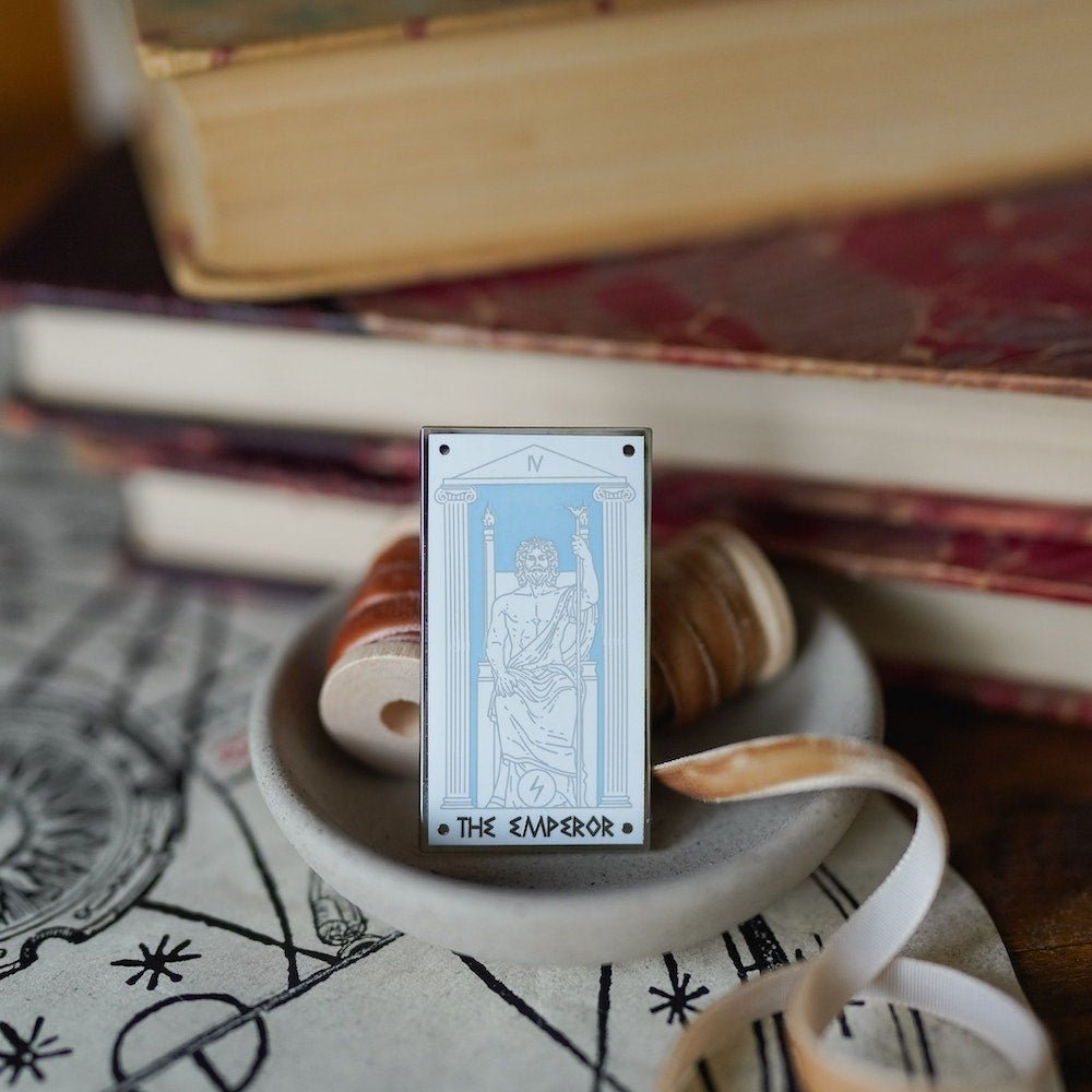 Zeus The Emperor, Mythology Tarot Enamel Pin with Zeus sitting on a throne between two columns and the words &quot;The Emperor” below.